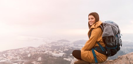/contentassets/b33819daa36740fcbfe21a76e5b71ddf/smiling-young-woman-sitting-top-mountain-with-her-backpack.jpg?w=454&h=220&mode=Crop&scale=Both